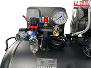 Close-up of the dual pressure gauges, regulator, outlet fitting and filter bowl on the oil-free air compressor.