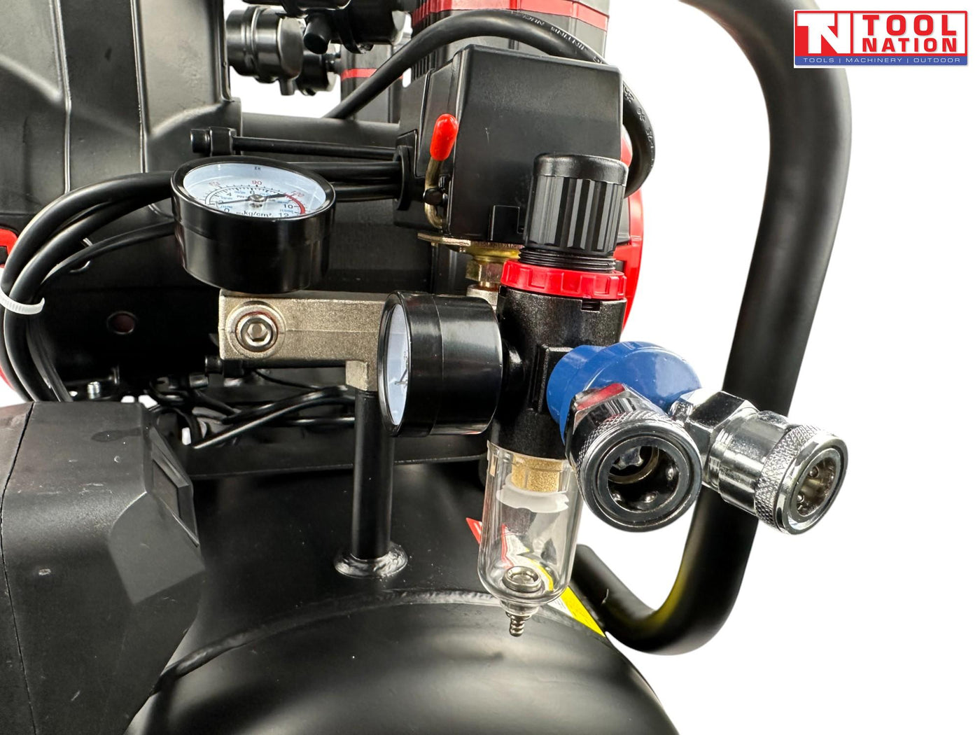 Close-up of the regulator, dual pressure gauges, outlet fitting and filter bowl on the oil-free air compressor.