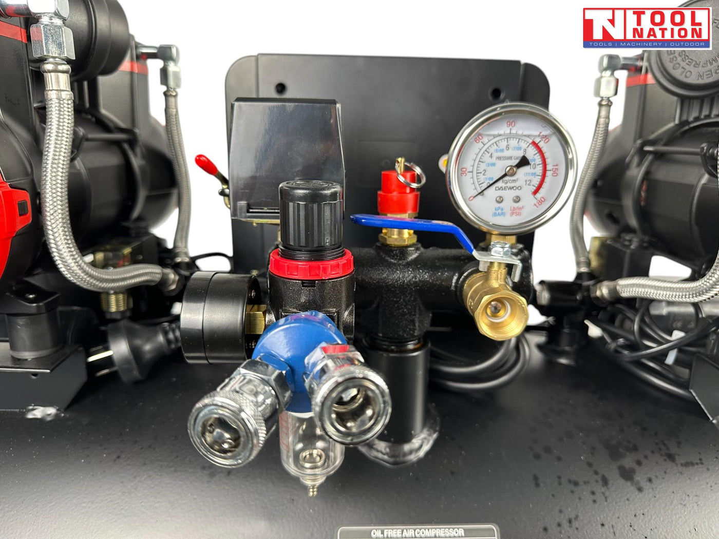 Close-up of the regulator assembly with dual quick-connect couplers, pressure gauge, regulator knob and filter bowl.