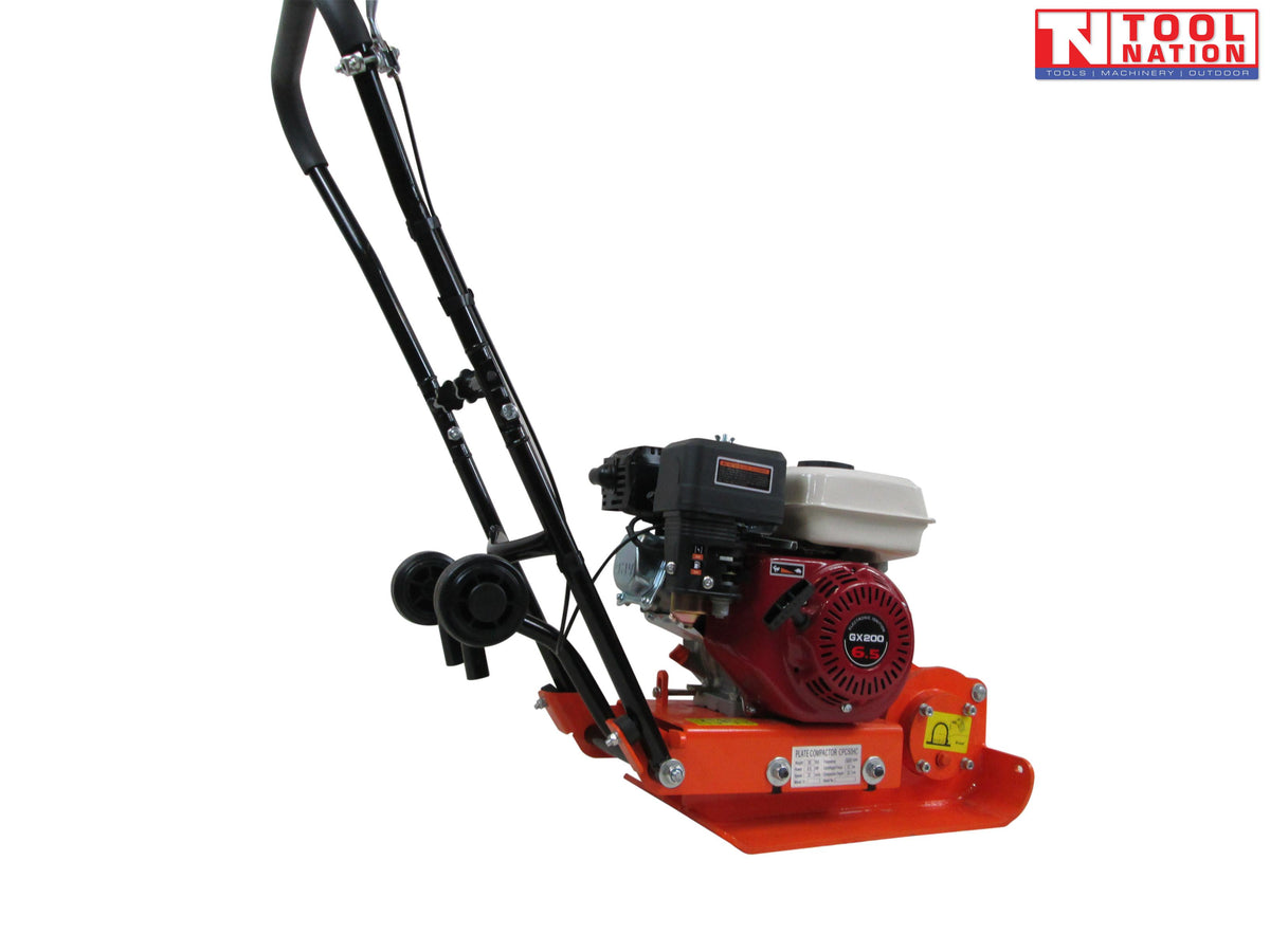 Side view of an orange plate compactor with petrol engine, black handle, wheels, warning labels, and logo in the top corner.