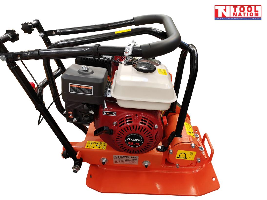 Orange plate compactor with petrol engine, black handle, base plate, warning labels, and logo in the top corner.