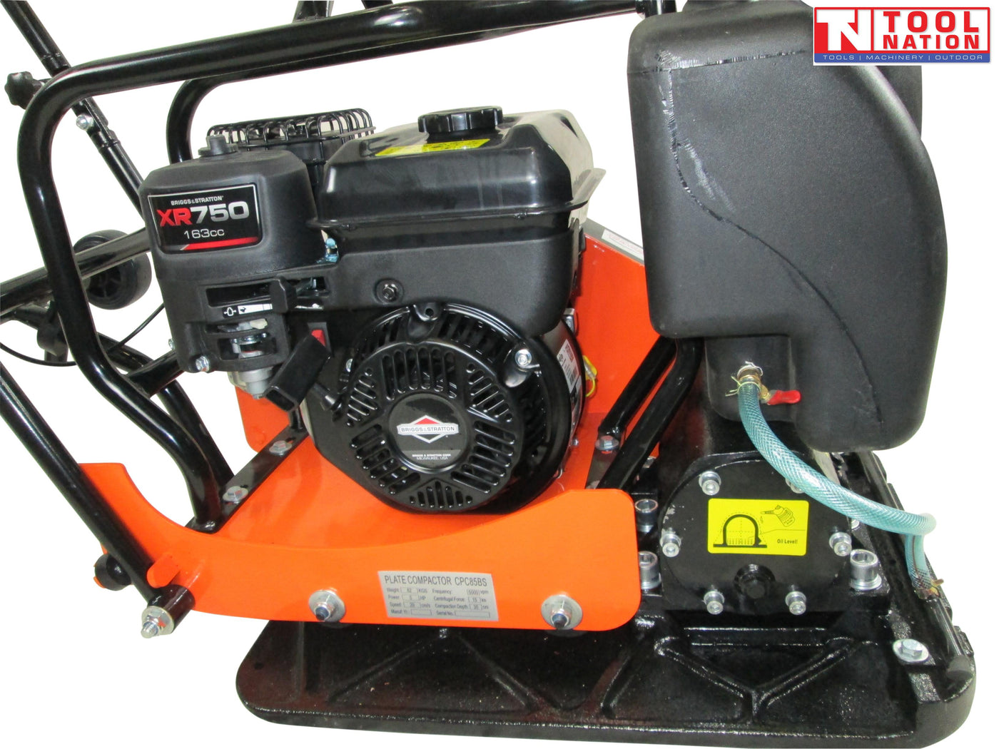 Close-up side view of an orange plate compactor showing the petrol engine, black water tank, hose, base plate, bolts, labels, and logo in the top corner.