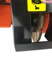 Close-up of a concrete grooving machine cutting blade inside a black guard with a yellow label and logo in the top corner.