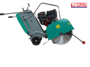Teal and grey floor saw with petrol engine, blade guard, diamond blade, wheels, handle, and pointer arm.