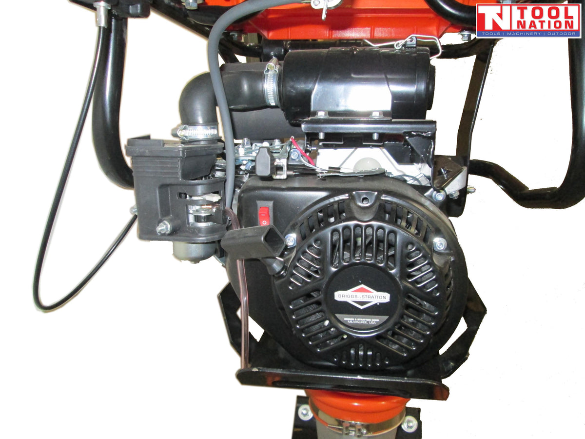 Close-up of a petrol engine on a tamping rammer showing the pull start, air filter, fuel components, frame, and logo in the top corner.