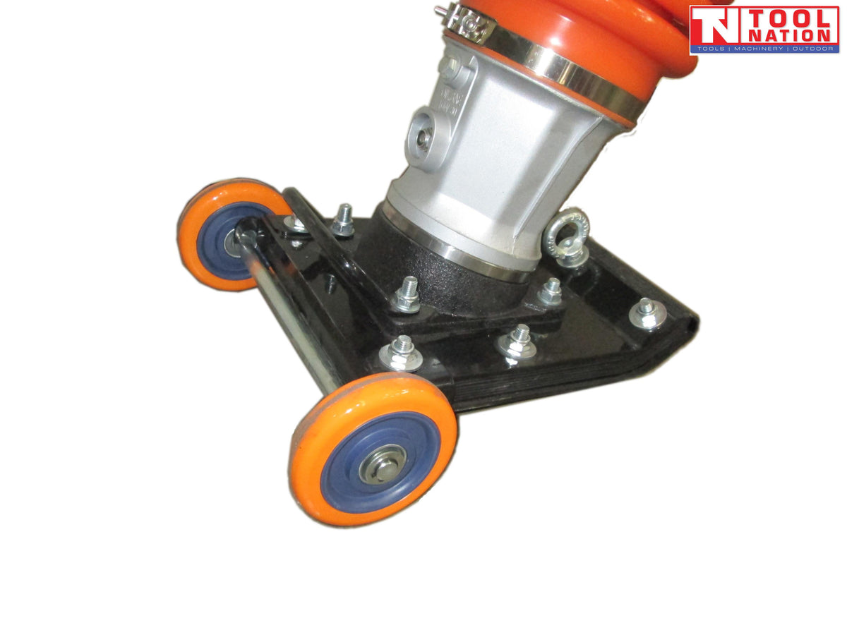 Close-up of a tamping rammer base showing orange wheels, black base plate, bolts, lifting eye, and lower bellows section.