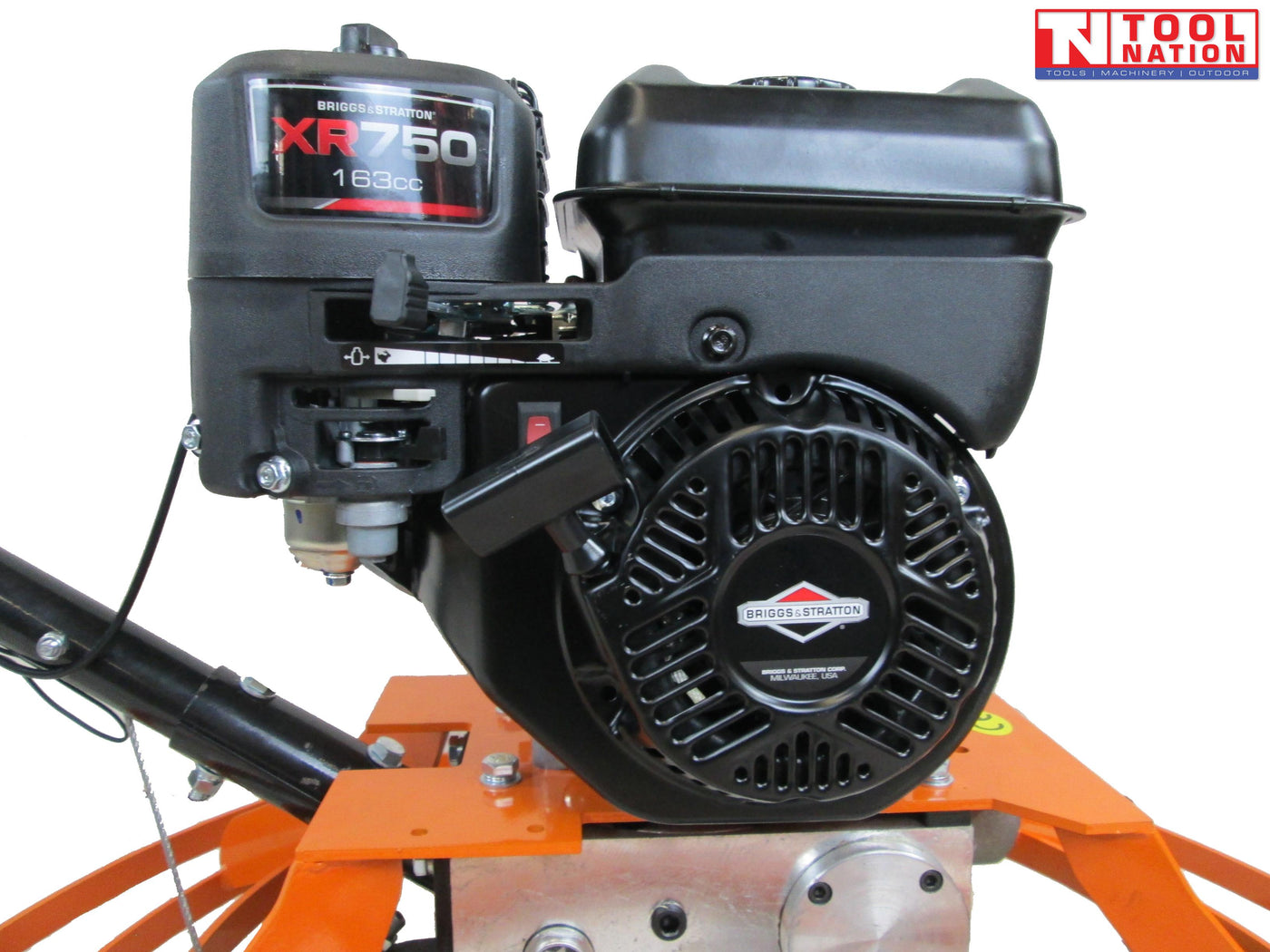 Close-up of a petrol engine mounted on an orange power trowel with handle section, bolts, and circular guard edge visible.