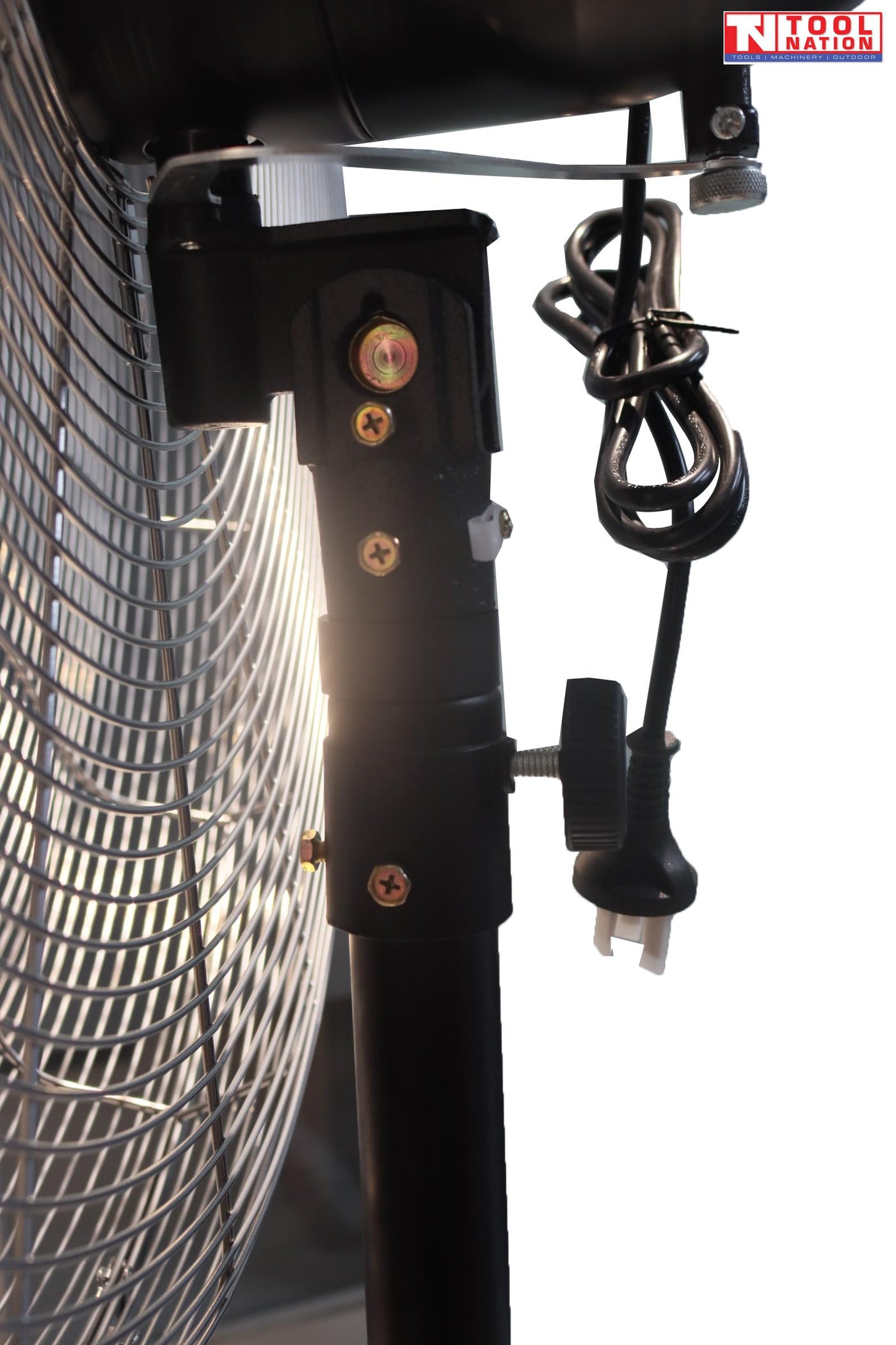 Side view of a large pedestal fan showing fan head, support pole, and cross base.