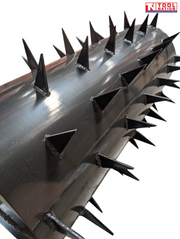 Close-up of a black cylindrical roller showing rows of raised metal spikes.