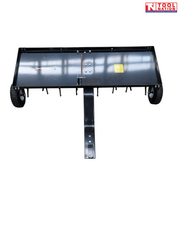 Front view of a black towable lawn aerator with a tray, drawbar, two tyres and visible coring tines underneath.