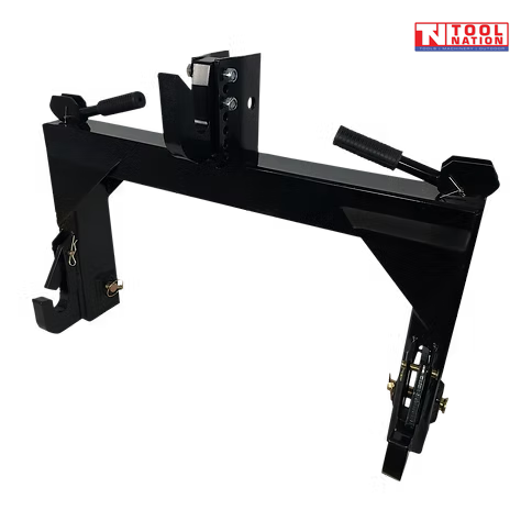Angled view of a black quick hitch attachment with top hook, side hooks, spring handles, pins, and a logo in the top right corner.