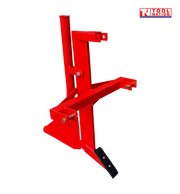 Rear angled view of a red ripper and pipelayer attachment with upright tube, mounting arms, black pointed tooth, bolts, pins, and a logo in the top right corner.