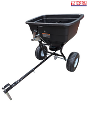Black tow-behind spreader with an open hopper, long drawbar, metal pin, two treaded tyres and Tool Nation logo.