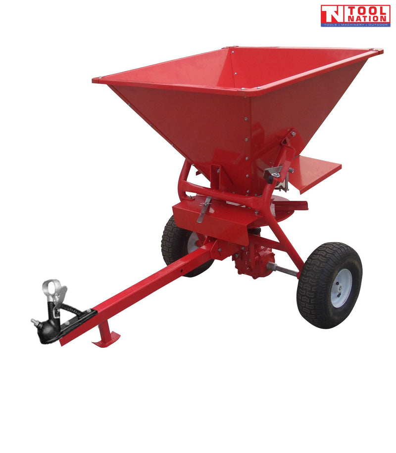 Red tow-behind spreader with an open hopper, long drawbar, metal coupler, two treaded tyres and Tool Nation logo.