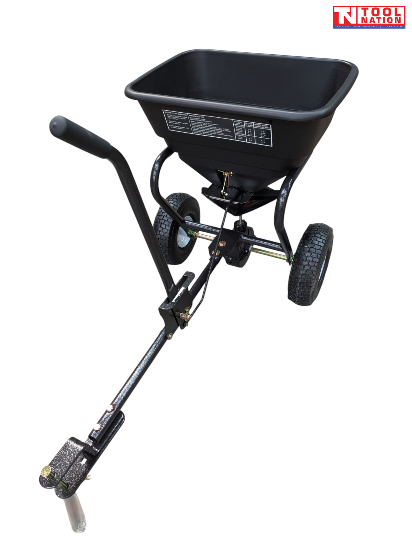 Black walk-behind spreader shown from above with an open hopper, long handle, two treaded tyres and Tool Nation logo.