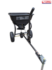 Black walk-behind spreader shown from the front side with an open hopper, long handle, two treaded tyres and Tool Nation logo.