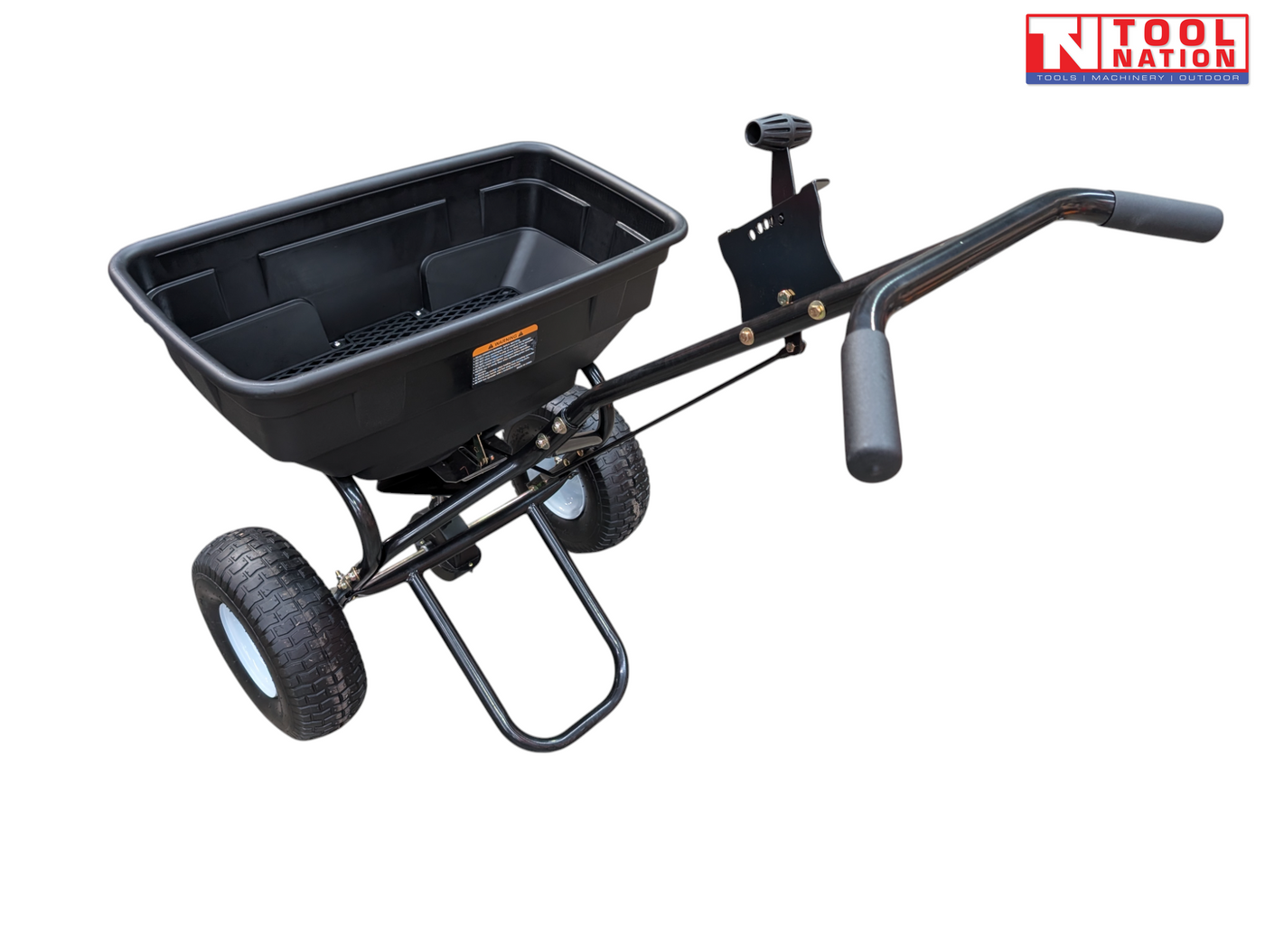 Black walk-behind spreader shown from above with an open hopper, long handle, two treaded tyres and Tool Nation logo.