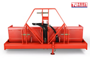 Rear view of a red bucket attachment with triangular mounting frame, black hydraulic hoses, pins, and support leg, with a logo in the top right corner.