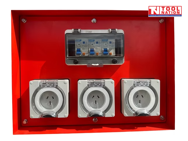 Close-up of three weatherproof power outlets and a breaker enclosure mounted inside a red generator outlet panel.