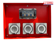 Close-up of three weatherproof power outlets and a breaker enclosure mounted inside a red generator outlet panel.