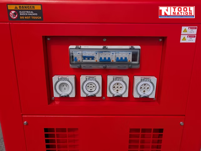 Close-up of the generator outlet panel with four covered power outlets and breaker switches set into the red side cabinet.