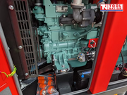 Internal view of the generator engine compartment showing the diesel engine, turbo assembly, battery, and lower cabinet components.