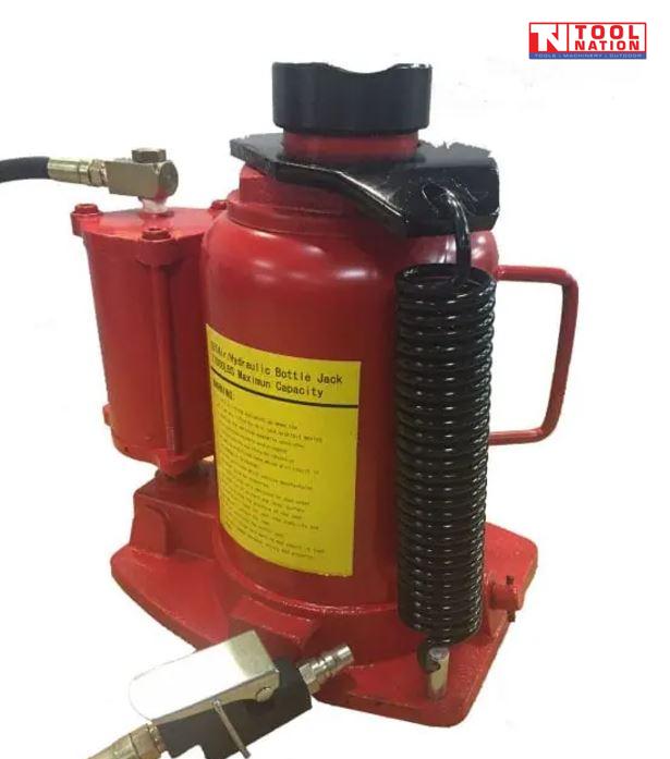 Close-up of red air hydraulic bottle jack with black hose, carry handle, and return spring