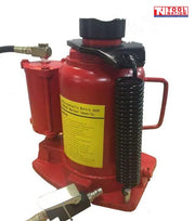 Close-up of red air hydraulic bottle jack with black hose, carry handle, and return spring