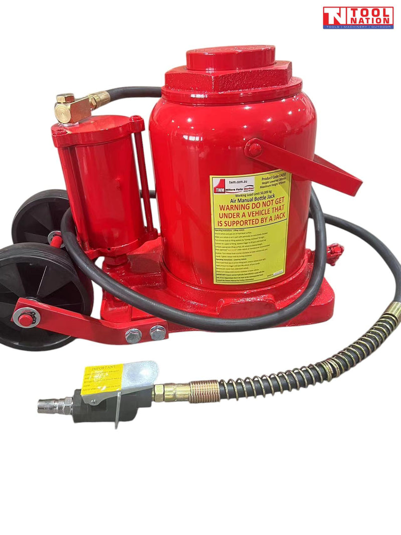 Close-up of red air hydraulic truck jack with wheels, black hose, air connector, and warning label