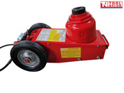 Close-up side view of red air hydraulic truck jack base with wheels, warning labels, and black saddle