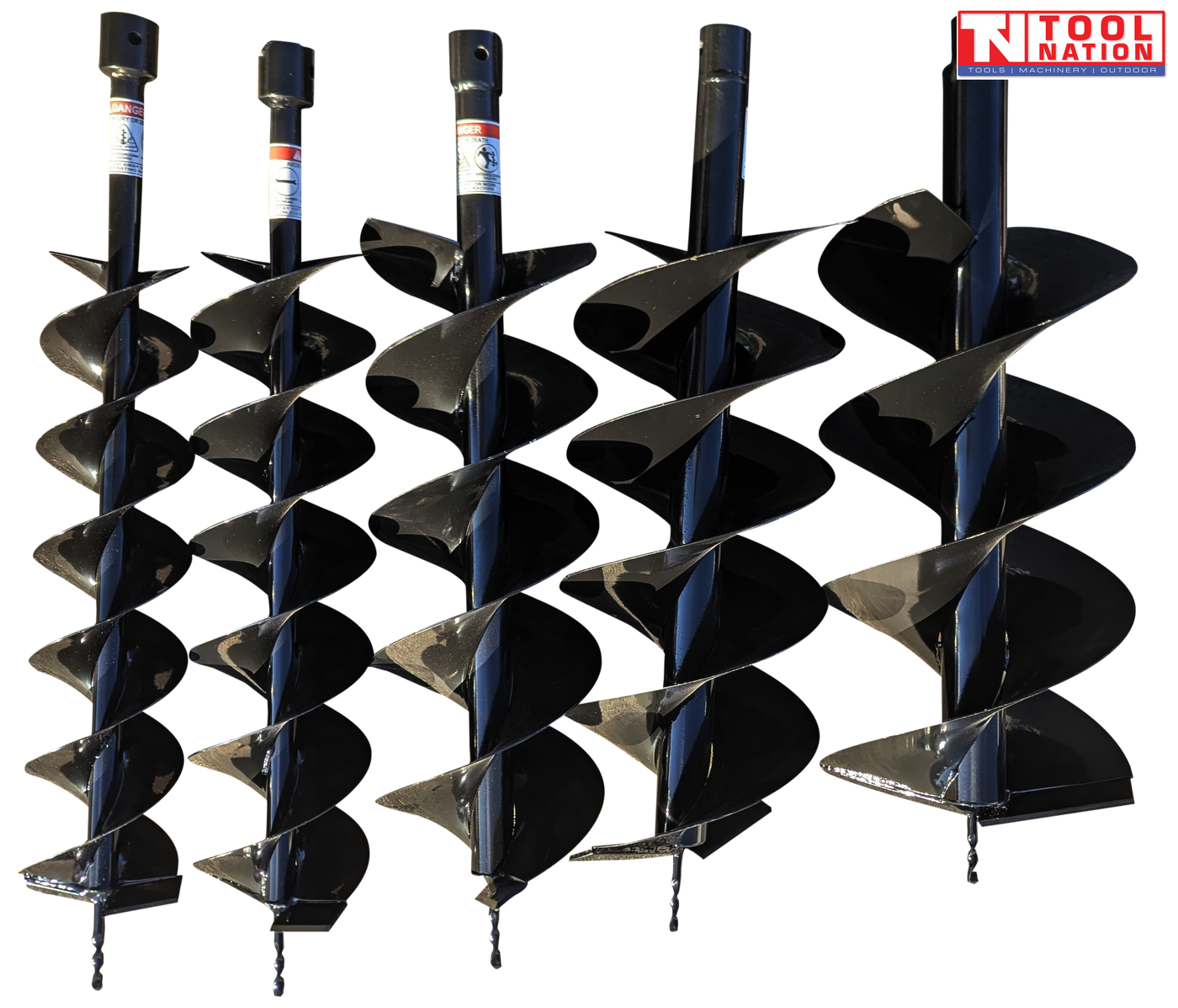 Close-up of multiple auger drill bits of different sizes placed on the ground.