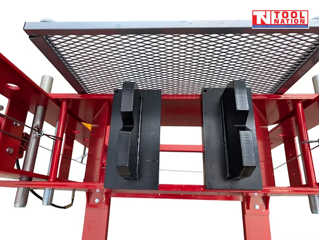 Full front view of a red 100 ton shop press with pressure gauge, mesh safety guard, press blocks, hand winch, and yellow foot pedal.