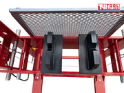 Full front view of a red 100 ton shop press with pressure gauge, mesh safety guard, press blocks, hand winch, and yellow foot pedal.