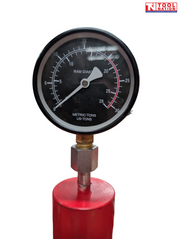 Close-up of a round pressure gauge mounted on top of the red shop press.