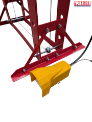 Close-up of yellow foot pedal, lower frame, cable, and base support
