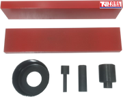 Front view of press accessory kit with two red press plates, three black adaptor pins, and black bearing shield on black background