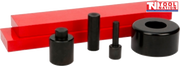 Angled view of press accessory kit with two red press plates, three black adaptor pins, and black bearing shield on black background