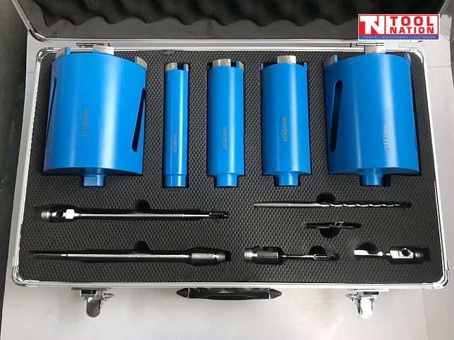Open carry case containing blue core drill bits, metal adapters, drill bits, black foam insert, and logo in the top corner.