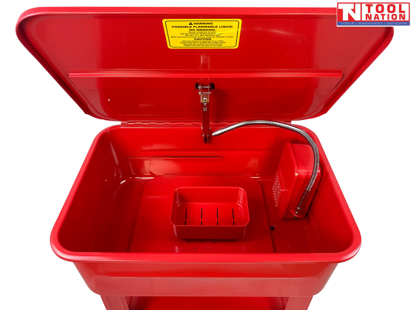 Red parts washer front view with lid open, flexible hose, yellow warning label, and lower shelf