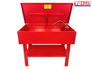 Red parts washer front view with lid open, flexible hose, yellow warning label, and lower shelf