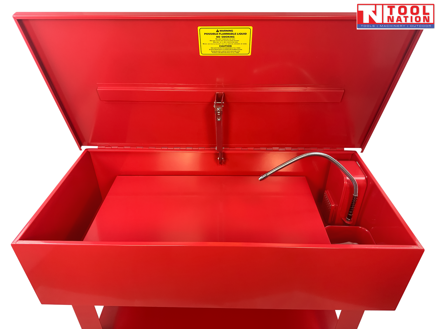 Red parts washer interior view with lid open, flexible hose, raised tray, and yellow warning label