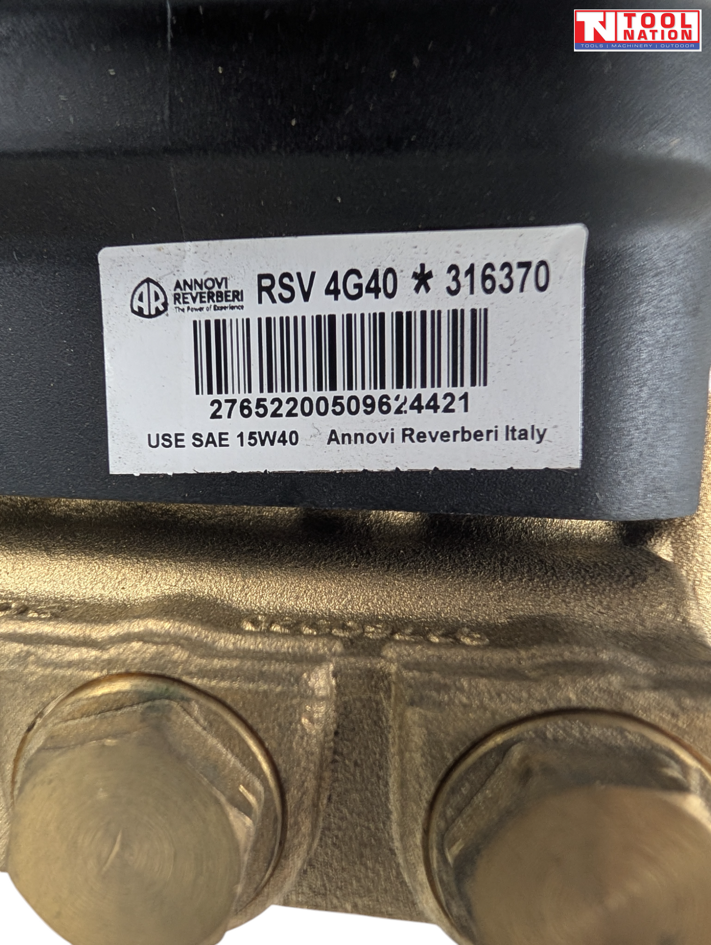 Close-up of a product label on a black pump housing above brass fittings, with a logo in the top right corner.