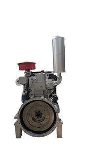 Diesel engine shown from the flywheel end with a large circular flywheel, red air filter and vertical silver exhaust visible.