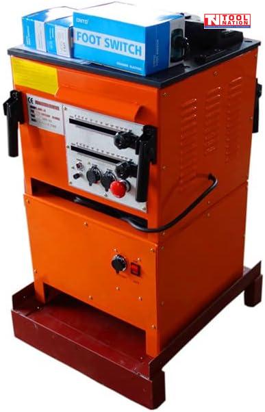 Angled view of an orange bench-mounted rebar bender and cutter with front controls, side handles, blue foot switch boxes on top, and logo in the top corner.