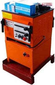 Angled view of an orange bench-mounted rebar bender and cutter with front controls, side handles, blue foot switch boxes on top, and logo in the top corner.