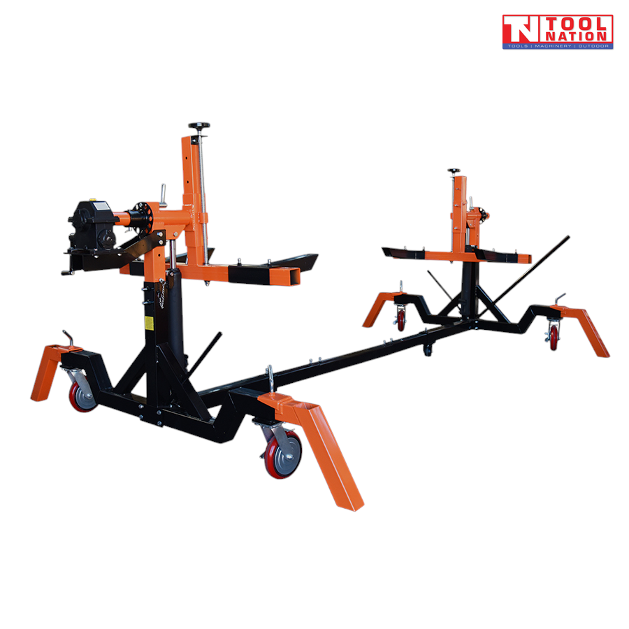 Angled view of black and orange car rotisserie with gearbox head assembly and castor wheels