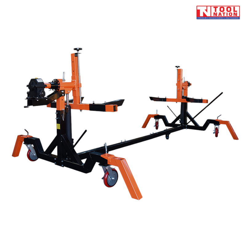 Angled view of black and orange car rotisserie with gearbox head assembly and castor wheels