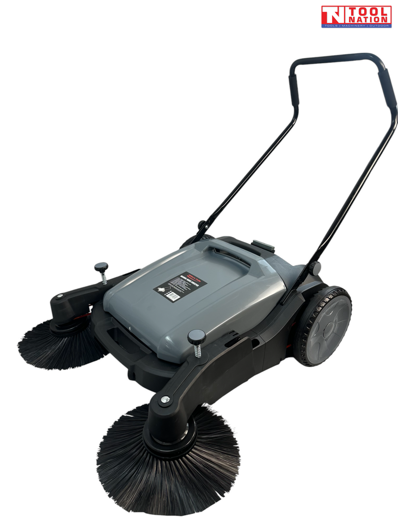 Grey and black manual sweeper shown at an angle with two round side brushes, rear wheels, upright handle and Tool Nation logo.