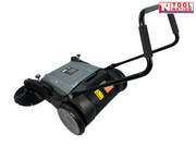 Rear side view of a grey and black manual sweeper with one round side brush, rear wheel, upright handle and warning labels.