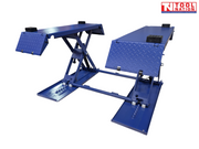 Angled front view of a blue mid-rise car lift with both platforms raised, diamond-plate end ramps folded down, black rubber blocks, and a light grey background.
